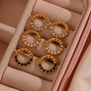 Detail of three pairs of gold-plated twisted earrings with pearls and green gemstones