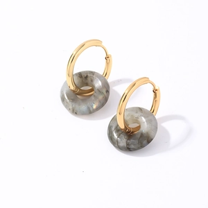 Détail de boucles d'oreilles en acier doré avec pendentifs en pierre naturelle grise