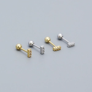 Macro shot of 925 silver T-shape stud earrings with zircon stones in gold and silver