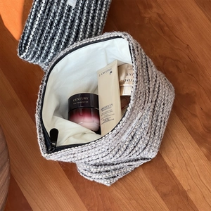 Detailed macro view of black and white tweed makeup bag showing spacious inner storage