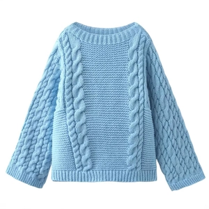 Light blue chunky cable knit sweater with a round neck and bell sleeves on white backdrop