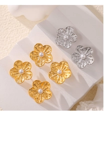 Detail showing textured gold and silver flower earrings with central pearl inlays