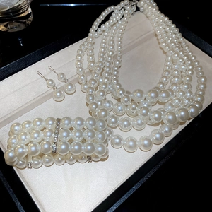 Detailed set of multi-layer pearl necklace, bracelet and earrings in a luxury gift box