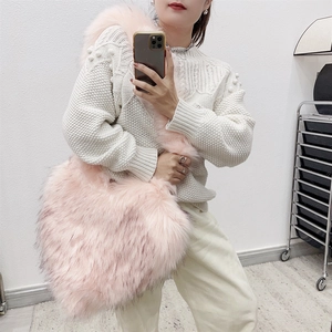 Detail of soft pink faux fur heart-shaped crossbody bag showing plush texture and large size