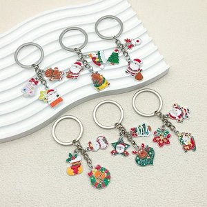 Set of 7 festive Christmas enamel keychains featuring Santa, reindeer, and gingerbread motifs