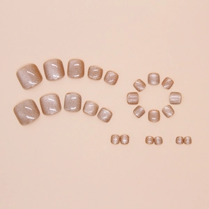 Macro view of champagne gold cat eye press-on toenails with shimmering glitter effect