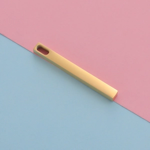 Close-up of a minimalist golden rectangular bar pendant with an oval top hole for DIY jewelry