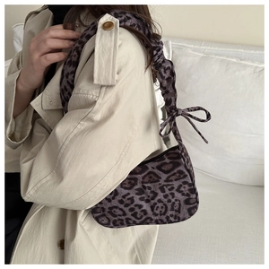 Dettaglio borsa leopardata in ecopelliccia con manico arricciato e fiocco decorativo
