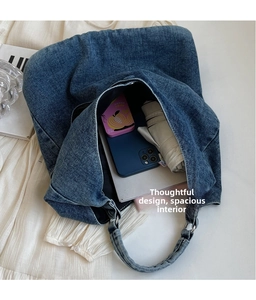 Detail view of large capacity denim tote bag showing interior space for phone and umbrella