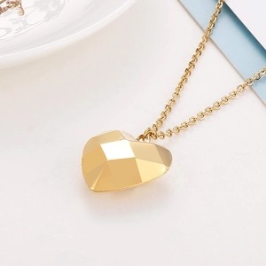 Gros plan d'un collier pendentif coeur évidé en or 18K avec facettes géométriques