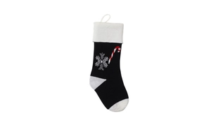 Detail of black knitted Christmas stocking with white snowflake and candy cane patterns