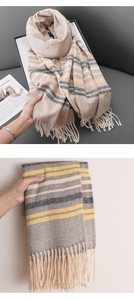 Detail of warm striped scarves with fringe in beige-pink and grey-yellow color options