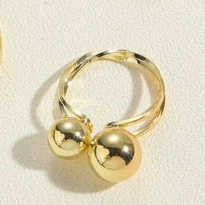 Vue détaillée d'une bague torsadée plaquée or avec deux boules polies aux extrémités