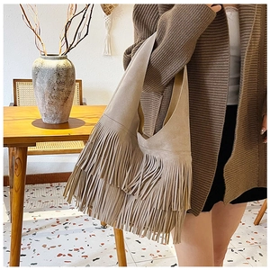 Detail of khaki suede shoulder bag with long tassel fringe in bohemian style