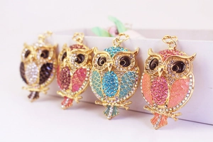 Close-up of sparkling rhinestone owl keychains in multiple colors with enamel finish