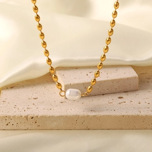 Detail of gold oval titanium steel bead chain with a natural freshwater pearl centerpiece