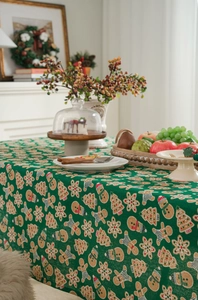 Detail of green linen tablecloth featuring gingerbread man and snowman Christmas patterns