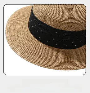 Close-up of wide brim straw boater hat with black sequined ribbon and fine weave texture