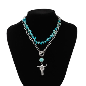 Detail of bohemian turquoise beaded layers with bull skull pendant on jewelry display