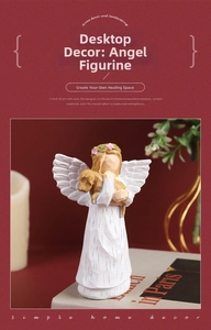 Close-up of white resin angel statue with dog on red background with candles