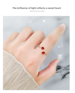 Close-up of double red heart gemstone ring in gold finish on a hand