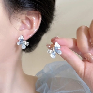 Vue détaillée de boucles d'oreilles papillon en argent avec cristal iridescent