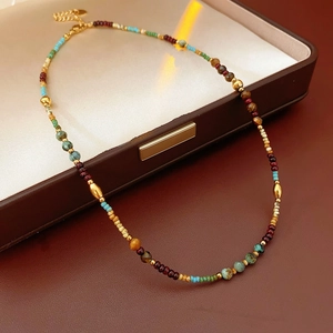 Close-up of bohemian beaded necklace with turquoise and garnet in a brown jewelry box
