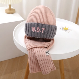 Detail of pink and grey ribbed knit kids hat and scarf set with V.O.T embroidery
