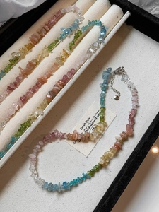 Detailed macro view of colorful irregular crushed stone necklace with silver lobster clasp