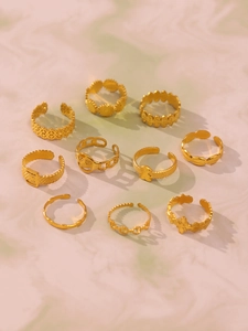 Dettaglio di un set di 10 anelli in acciaio inossidabile dorato con design floreali regolabili