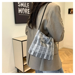 Detail of black and white checkered shoulder bag with lace polka dot stripes on fabric