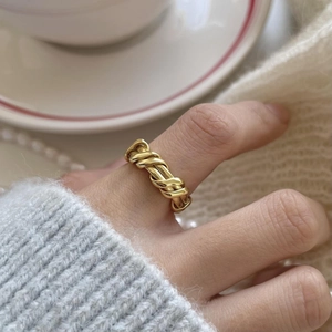 Detail of a gold braided textured ring on a hand with elegant minimalist design
