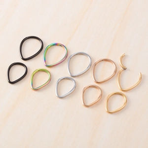 Water drop 316L stainless steel nose rings in five colors and two sizes on wood surface