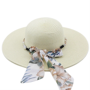 Detailed texture of straw sun hat with floral ribbon and elegant pearl embellishments