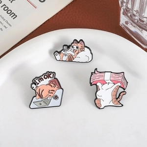 Three cute orange cat enamel pins showing office cats working and relaxing on ceramic plate