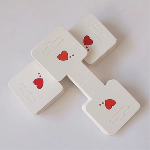 White jewelry display cards with red heart patterns and hanging holes for hair accessories
