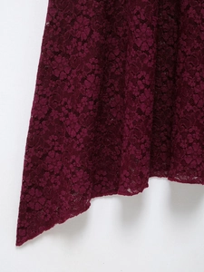 Detailed macro view of dark burgundy floral lace fabric showing intricate weave patterns
