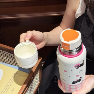 Close-up of white cartoon cat thermal bottle featuring a detachable multi-use teacup lid