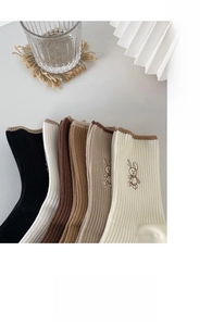 Close-up of ribbed cotton socks featuring cute rabbit embroidery in earthy tones