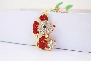 Close-up of golden mouse keychain with sparkling clear and red rhinestones details
