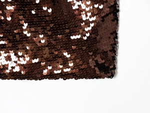 Detailed macro shot of shimmering brown sequin fabric with metallic reflective finish