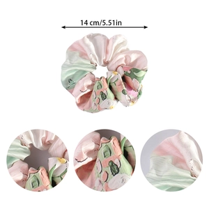 Detail view of 14cm pink and green floral satin scrunchie with fabric texture and dimensions