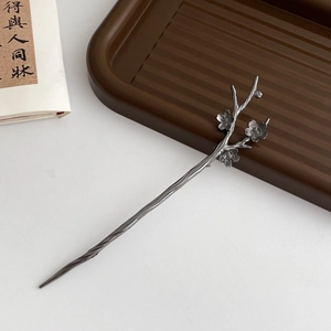 Detail of silver plum blossom hair stick featuring vintage tassel and intricate branch design