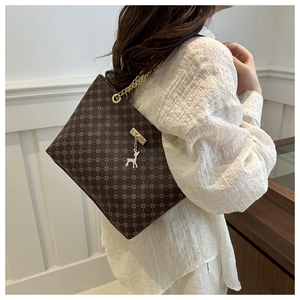 Close-up of retro brown tote with star print, gold chain strap, and deer charm detail