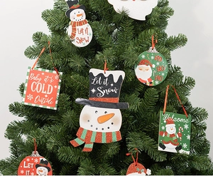 Detail of glittery wooden Christmas tree ornaments with Snowman and Santa motifs