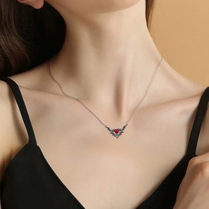 Gothic bat wing necklace with red heart pendant worn by model on neck