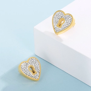 Detail of heart-shaped gold lock earrings with crystal pavé and center keyhole