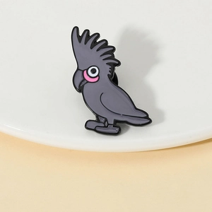 Détail d'une broche en émail en forme de cacatoès avec finition en alliage gris foncé