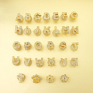 Close-up of 8mm gold alloy rhinestone letters and charms for DIY jewelry making