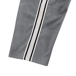 Close-up of black and white side stripes on gray corduroy casual men's trousers